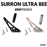 Top view of shift/foot lock with a white background showcasing both colors, and all hardware and bolts and spacers included, with the pegs for the shift lock done as well. Gloss black and chrome shift locks