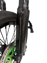 A close up picture of the carbon fiber fork guard installed on the bike. White background. The glossy weave pattern is clearly visible.